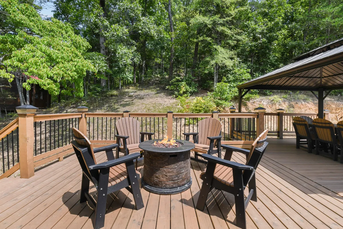 A cozy fire pit area with comfortable seating, set amidst tall trees. The scene is made for socializing, storytelling, or simply enjoying the crisp mountain air and clear night skies.